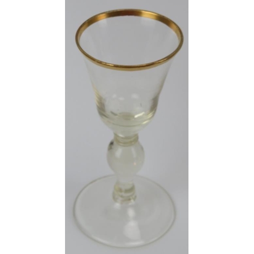 30 - A pair of European glass wine glasses, probably early 19th century. Both with gilt rims and knopped ... 