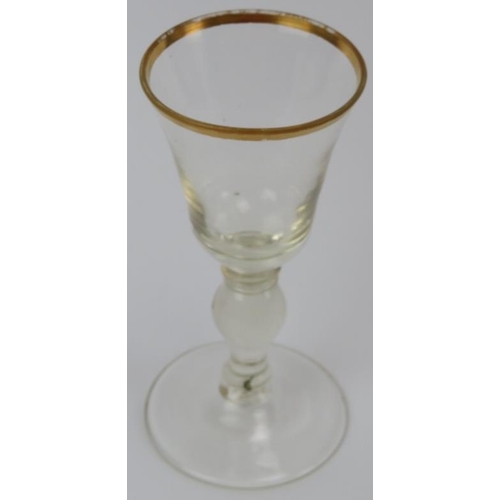 30 - A pair of European glass wine glasses, probably early 19th century. Both with gilt rims and knopped ... 