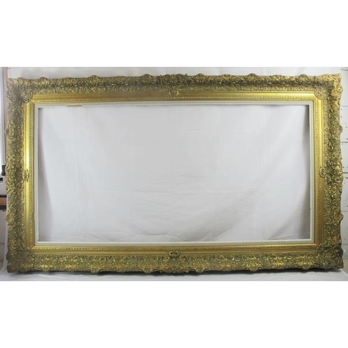 571 - A large late 19th/early 20th century gilt gesso and pine picture frame, relief moulded and swept cla... 