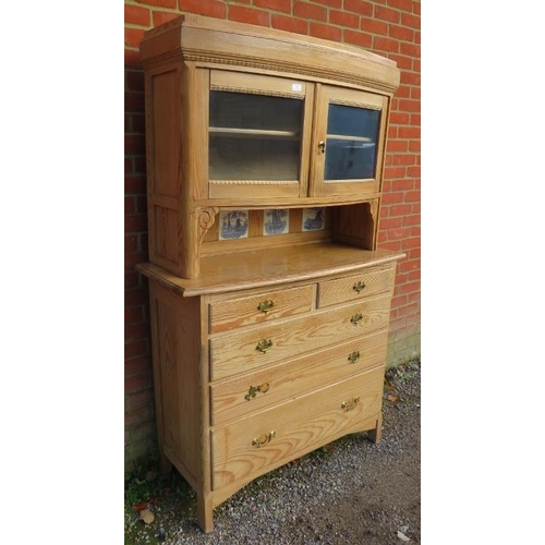 701 - A 19th century stripped pine bowfront cabinet on chest, having two glazed panelled doors above reces... 