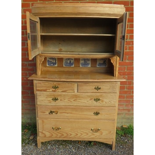 701 - A 19th century stripped pine bowfront cabinet on chest, having two glazed panelled doors above reces... 