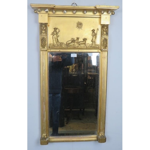 702 - An English Regency period gilt gesso pier glass mirror of breakfront form with relief moulded panel ... 