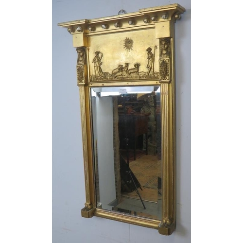 702 - An English Regency period gilt gesso pier glass mirror of breakfront form with relief moulded panel ... 