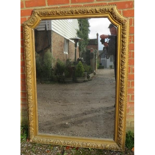 703 - A large 19th century French giltwood wall mirror, of rectangular form with swept inverted top corner... 