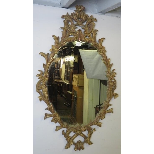 706 - A highly decorative Georgian revival carved giltwood wall mirror, 20th century, decorated with scrol... 