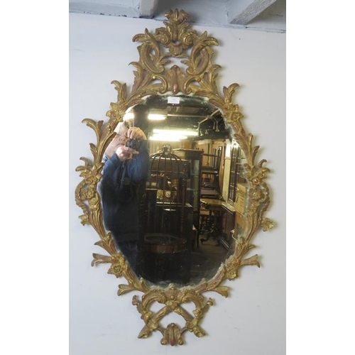 706 - A highly decorative Georgian revival carved giltwood wall mirror, 20th century, decorated with scrol... 