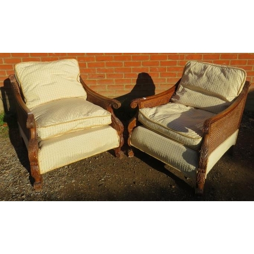 707 - A pair of early/mid 20th century Bergere armchairs, having ornately carved show-wood frames, double-... 