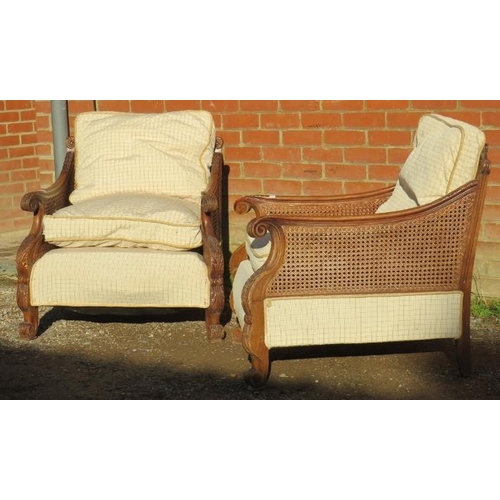 707 - A pair of early/mid 20th century Bergere armchairs, having ornately carved show-wood frames, double-... 