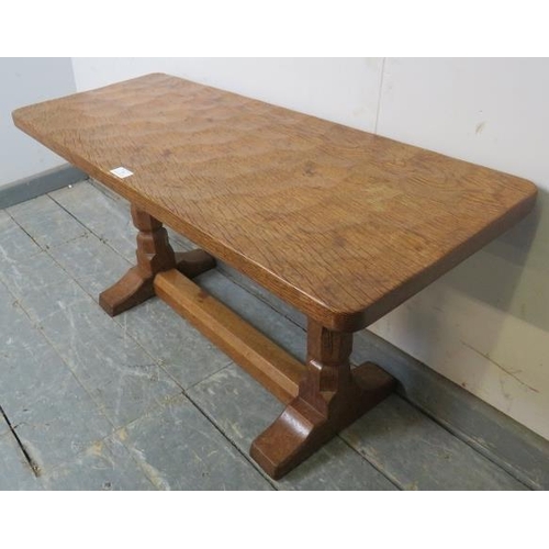 709 - A vintage carved oak low side table by Robert Thompson, the 'Mouseman', the adzed top on tapering oc... 