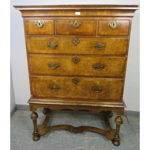 711 - An antique cross-banded walnut chest on stand in the Queen Anne style, the swept moulded cornice abo... 