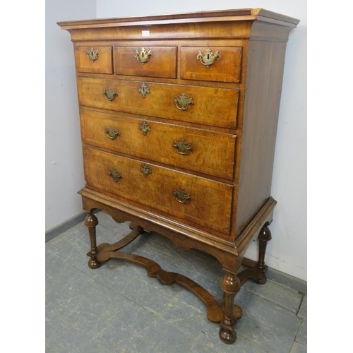 711 - An antique cross-banded walnut chest on stand in the Queen Anne style, the swept moulded cornice abo... 