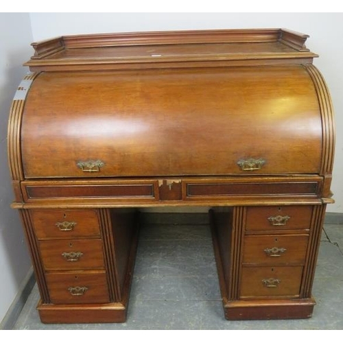 713 - A 19th century roll top desk, having 3/4 gallery top above the revolving cylinder enclosing drawers ... 