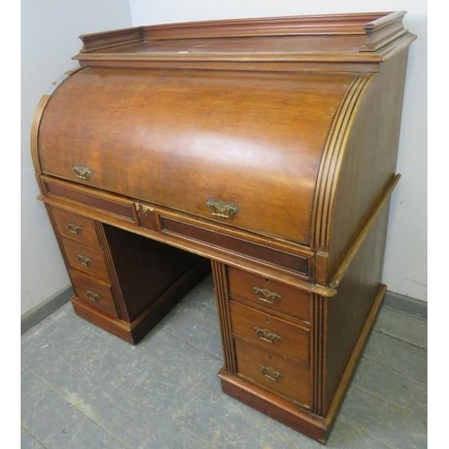 713 - A 19th century roll top desk, having 3/4 gallery top above the revolving cylinder enclosing drawers ... 