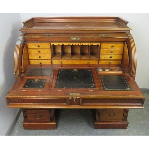 713 - A 19th century roll top desk, having 3/4 gallery top above the revolving cylinder enclosing drawers ... 