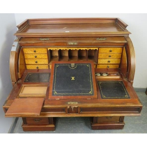 713 - A 19th century roll top desk, having 3/4 gallery top above the revolving cylinder enclosing drawers ... 