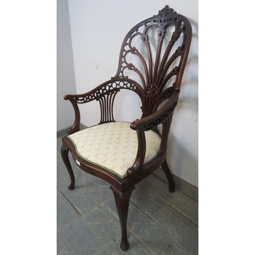 719 - An Edwardian mahogany open sided armchair, having a very ornately carved and pierced back, the seat ... 