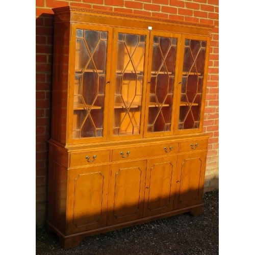 723 - A reproduction yew wood library bookcase, having a dentil cornice above four astral glazed doors, ho... 