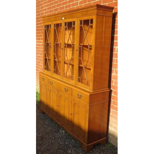 723 - A reproduction yew wood library bookcase, having a dentil cornice above four astral glazed doors, ho... 