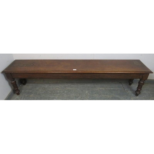 725 - An unusually long 19th century oak hall bench/window seat, carved decoration to one end of seat, tur... 