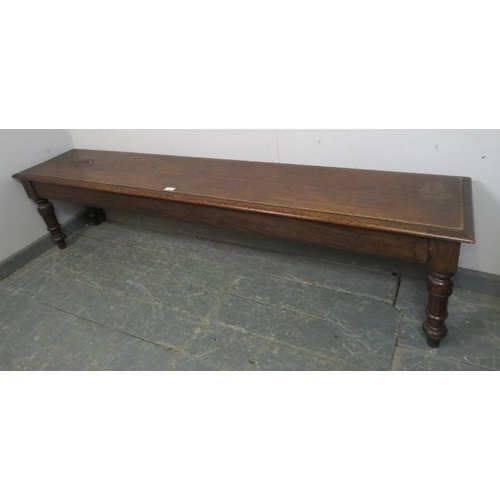 725 - An unusually long 19th century oak hall bench/window seat, carved decoration to one end of seat, tur... 