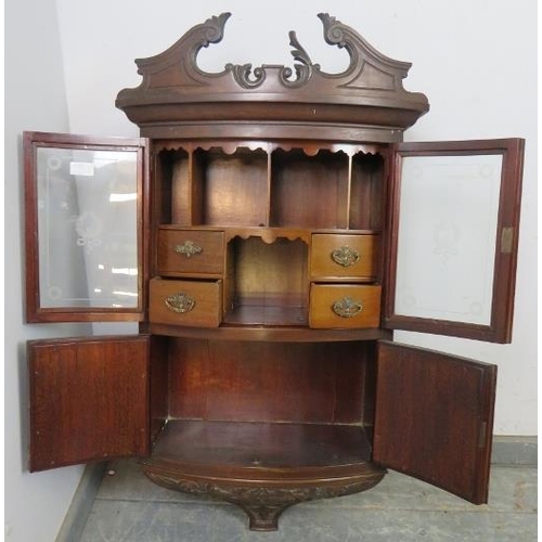 735 - An Edwardian ornately carved mahogany bow front hanging wall cabinet, shaped pediment above etched g... 