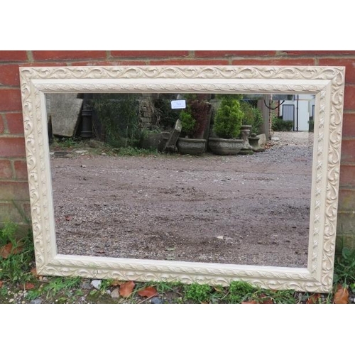 740 - A period-style cream finished wall mirror with relief moulded decoration.
90cm x 65m (approx).