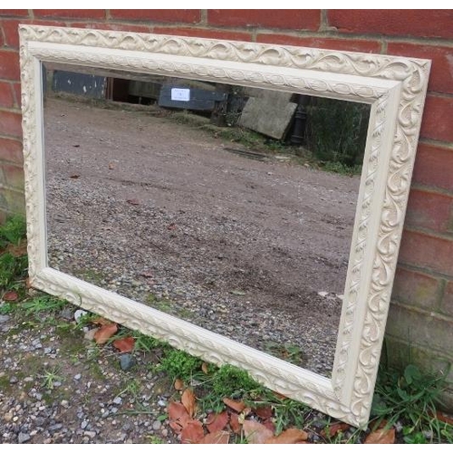 740 - A period-style cream finished wall mirror with relief moulded decoration.
90cm x 65m (approx).