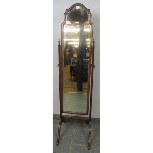 742 - A turn of the century walnut cheval mirror, within a shaped surround, the uprights with turned finia... 