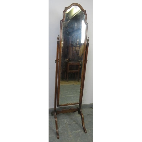 742 - A turn of the century walnut cheval mirror, within a shaped surround, the uprights with turned finia... 