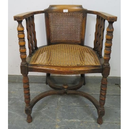 747 - An antique fruitwood Continental bergère tub chair, the curved arms joined by shaped spindles and ba... 