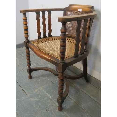 747 - An antique fruitwood Continental bergère tub chair, the curved arms joined by shaped spindles and ba... 