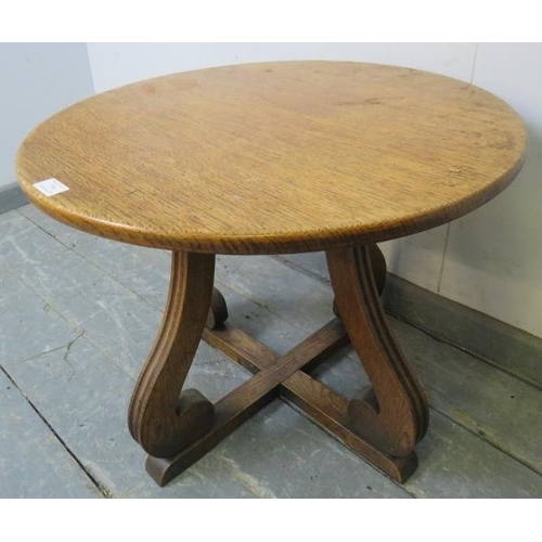 750 - An early 20th century oak low side table, circular top on scrolled supports and cross-stretcher.
Dia... 