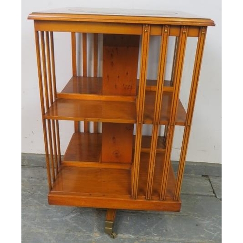 753 - A reproduction cross-banded yew wood revolving book table, with inset gilt tooled green leather top.... 