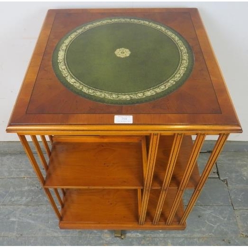 753 - A reproduction cross-banded yew wood revolving book table, with inset gilt tooled green leather top.... 