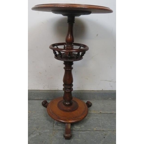 770 - A Victorian mahogany circular lamp table, supported on a baluster turned column having a basket with... 