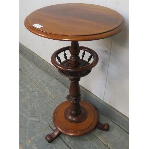 770 - A Victorian mahogany circular lamp table, supported on a baluster turned column having a basket with... 