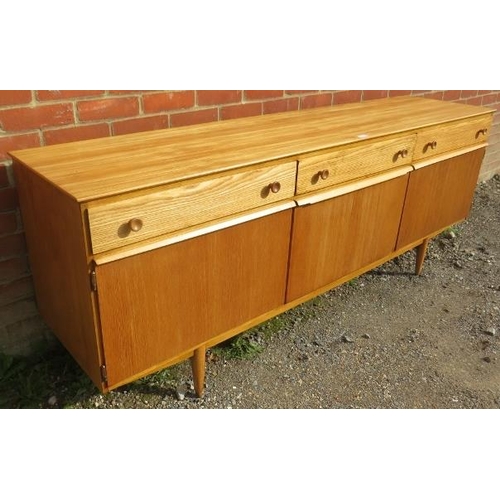 821 - A mid-century ash sideboard, housing three short drawers with turned wooden handles, above a fall fr... 