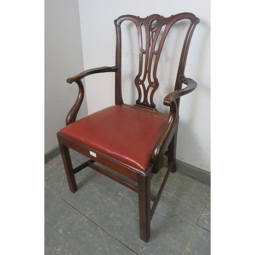 829 - A Georgian mahogany elbow chair in the manner of Chippendale, having carved and pierced back, above ... 