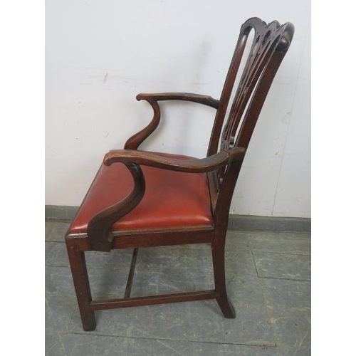 829 - A Georgian mahogany elbow chair in the manner of Chippendale, having carved and pierced back, above ... 