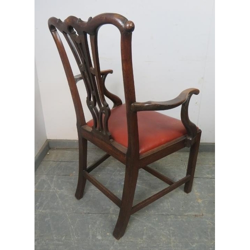 829 - A Georgian mahogany elbow chair in the manner of Chippendale, having carved and pierced back, above ... 