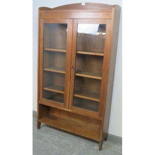 863 - A turn of the century walnut glazed bookcase, housing three height adjustable shelves above an open ... 