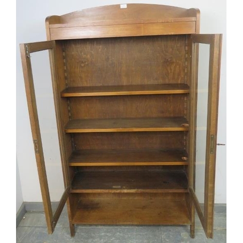 863 - A turn of the century walnut glazed bookcase, housing three height adjustable shelves above an open ... 