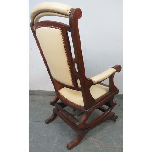 864 - An early 20th century American mahogany ‘Dexter’ rocking chair, re-upholstered in cream leather with... 