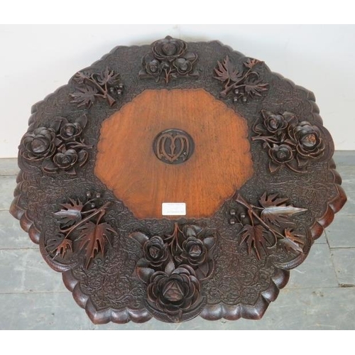 869 - A well-carved early 20th century Anglo Indian octagonal table, the top depicting fruiting vines and ... 