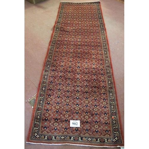 902 - A North West Persian Bidsar runner with a central repeat pattern field on a pale red ground. 300cm x... 