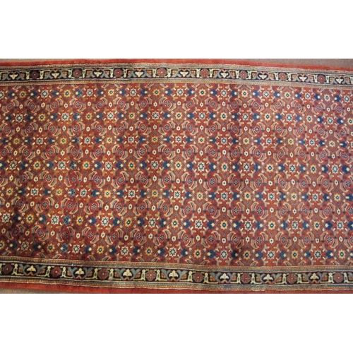 902 - A North West Persian Bidsar runner with a central repeat pattern field on a pale red ground. 300cm x... 