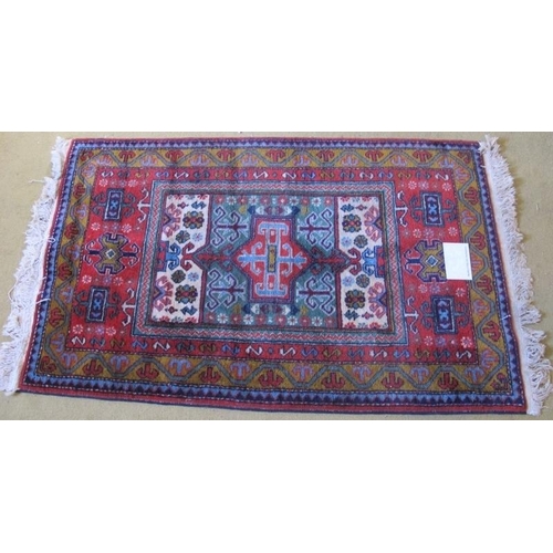 912 - A late 20th century Persian rug with central block panel in good condition. 137cm x 78cm overall.