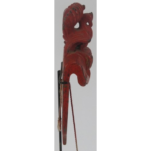 95 - A Southeast Asian red lacquered and carved wood plumb line. Modelled with surmounted bird and cord s... 