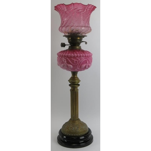 216 - A Victorian brass and pink milk glass oil lamp with etched cranberry glass shade. Marked ‘Duplex. 66... 