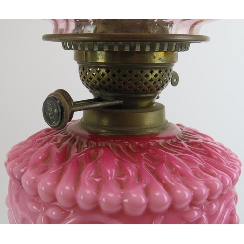 216 - A Victorian brass and pink milk glass oil lamp with etched cranberry glass shade. Marked ‘Duplex. 66... 